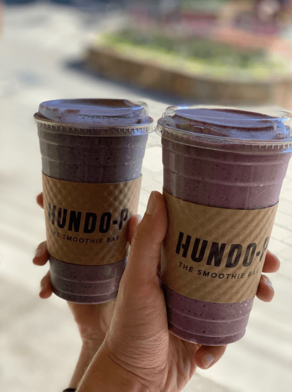 Hundo-P smoothies in a cup held by hand